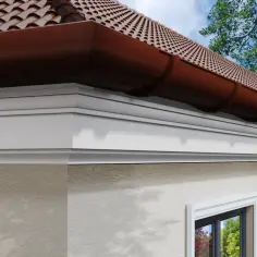 Elegancki gzyms na zewnątrz domu, pod brązową rynną i dachówką. Idealne wykończenie elewacji.