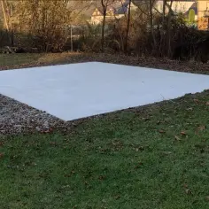 Solidny, równy beton pod blaszak, gotowy na nowe wyzwania. Otoczony żwirem i jesiennymi liśćmi.