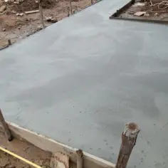 Świeżo wylana płyta fundamentowa pod garaż blaszany. Beton schnie, tworząc solidną podstawę.