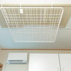 Białe, składane suszarki balkonowe sufitowe wiszą pod sufitem, gotowe do suszenia prania.