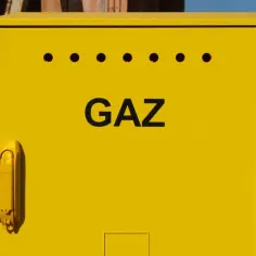 Żółta skrzynka gazowa z napisem "GAZ" na tle budowy. Zastanawiasz się, ile kosztuje ponowne podłączenie gazu?