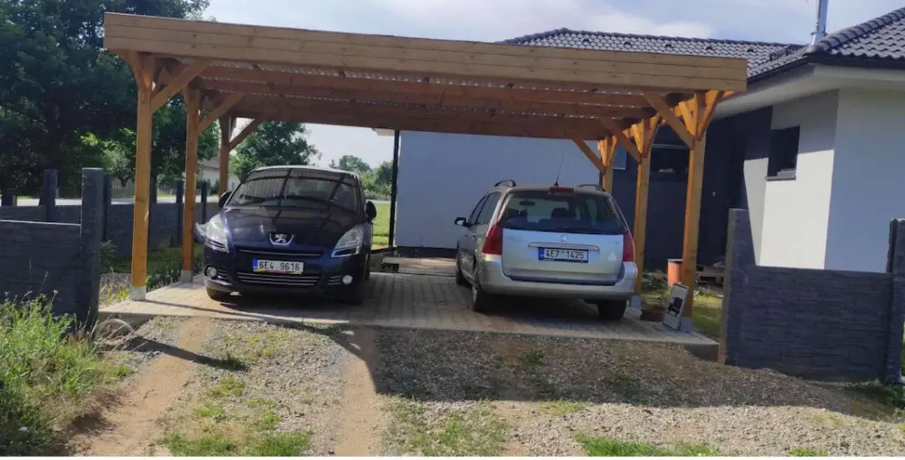 Drewniana wiata na dwa samochody, z widocznymi wymiarami, chroni pojazdy przed słońcem i deszczem.