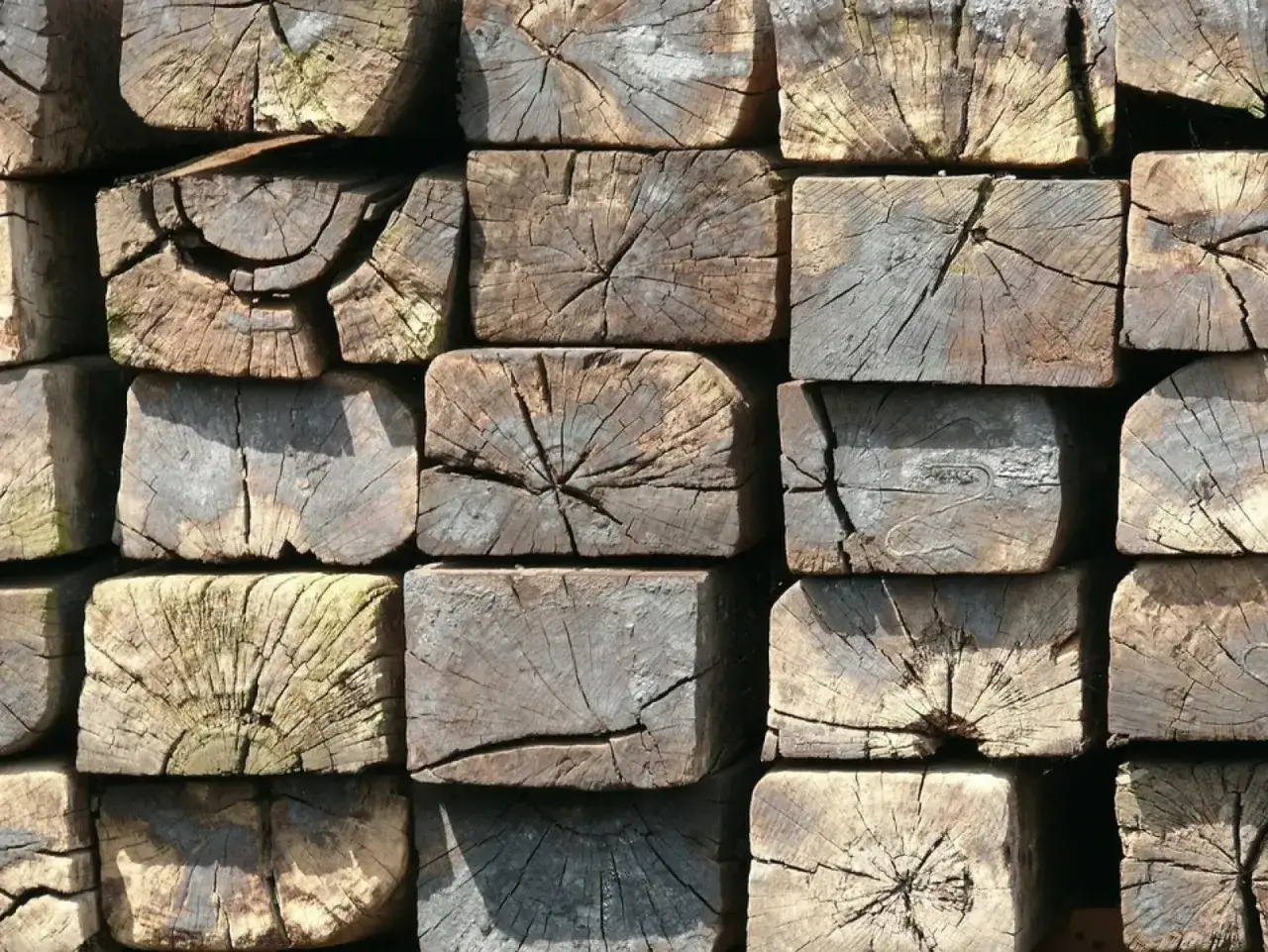 Stare, drewniane podkłady kolejowe w ogrodzie, tworzące ciekawą, rustykalną kompozycję.